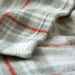 Close-up of folded IKEA ODENSLÄTA check blanket showing smooth, cosy texture