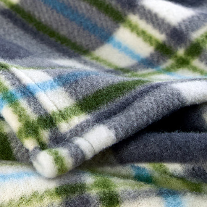 Close-up of IKEA ODENSLÄTA blanket showing soft textured check weave in grey, green and white