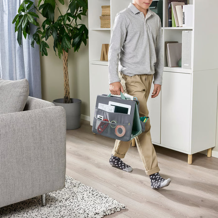 Child carrying IKEA ÖVNING organiser with tablet and study supplies at home