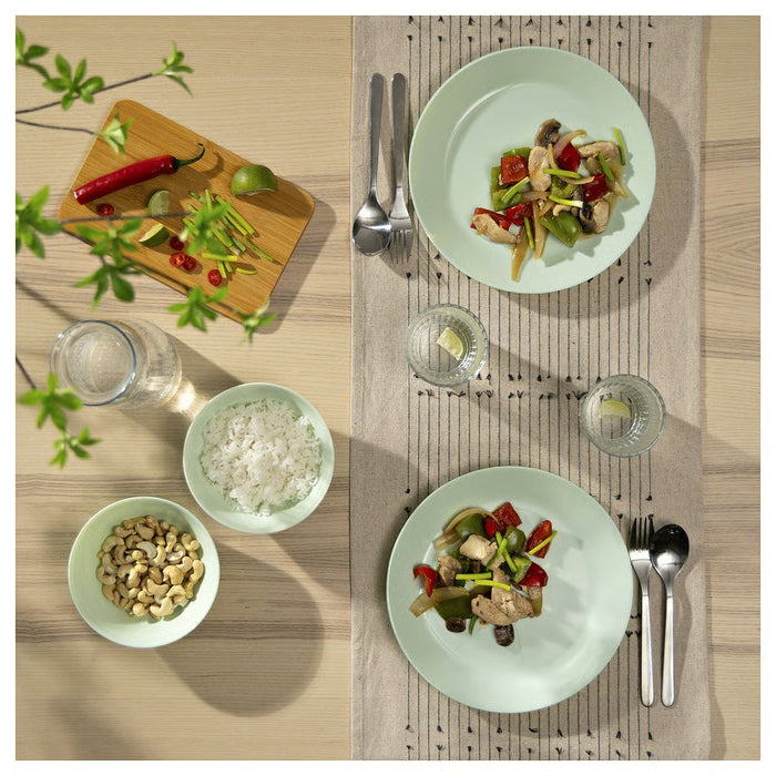 A round, light green ceramic plate with a glossy finish, smooth surface, and slightly raised edges, ideal for serving meals or snacks