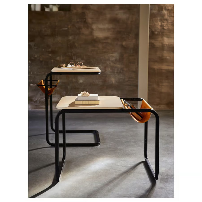 OLSERÖD side table with mustard fabric pouch beside black metal frame on wood surface