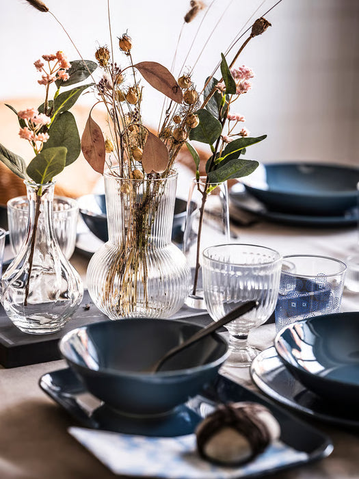 IKEA PÅDRAG clear glass vase with dried flowers on elegant dining table setting with blue dishes