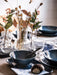 IKEA PÅDRAG clear glass vase with dried flowers on elegant dining table setting with blue dishes