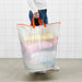 Person carrying IKEA PÄRKLA white laundry bag filled with colourful clothes using long top handle
