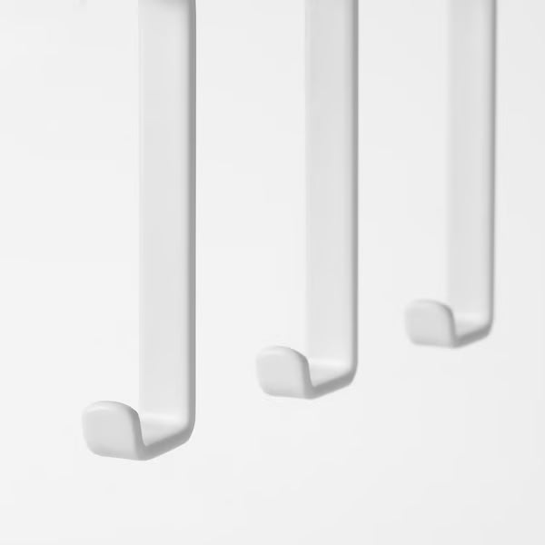 Three white IKEA PÅLYCKE hooks mounted in a row under a shelf easy no-drill install