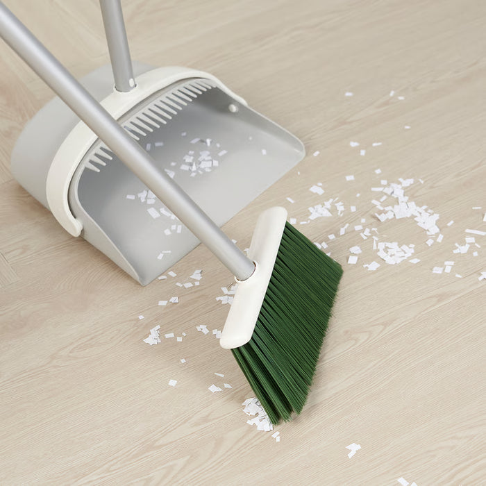  IKEA PEPPRIG dustpan and broom set on wooden floor with white confetti showing folded dustpan in use