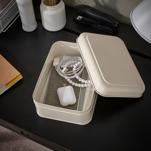  IKEA PLOGFÅRA storage box with lid open on dark desk, holding computer mouse, charging cord and pens