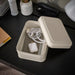  IKEA PLOGFÅRA storage box with lid open on dark desk, holding computer mouse, charging cord and pens