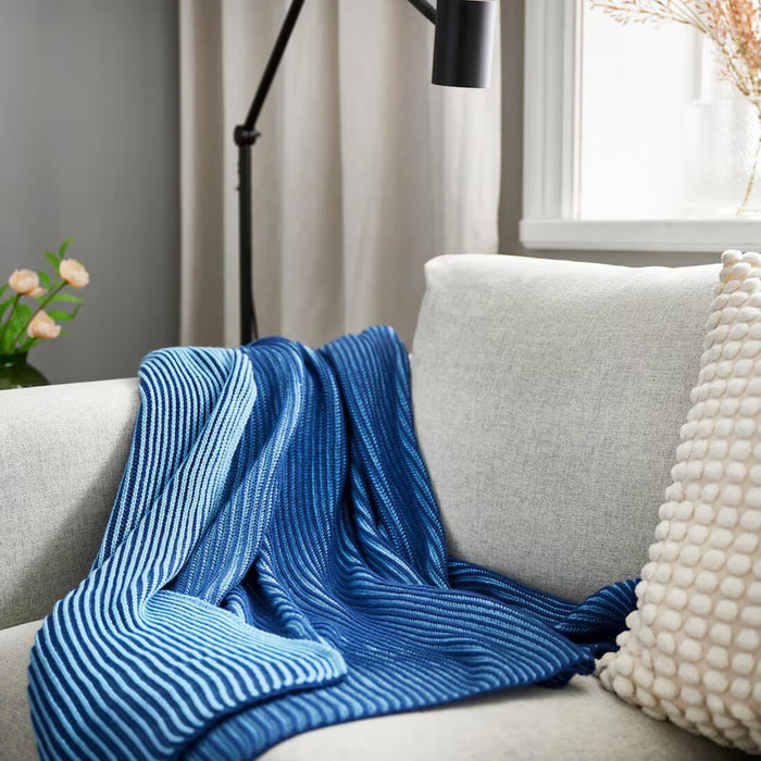 IKEA PRAKTFJÄRIL blue throw blanket, 130x170 cm, adding a cozy touch to a bed 10582842