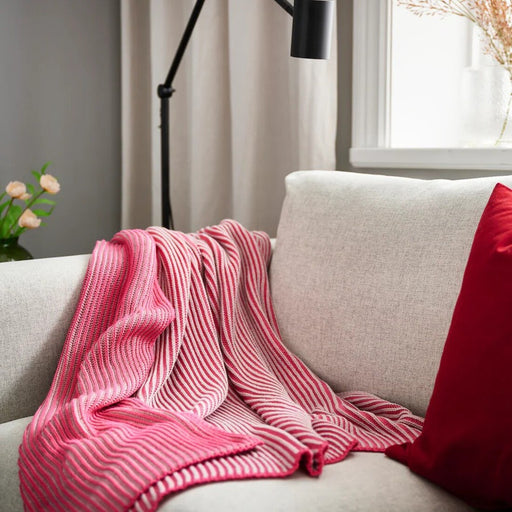 IKEA PRAKTFJÄRIL pink throw on the sofa, creating a cozy atmosphere-50582840