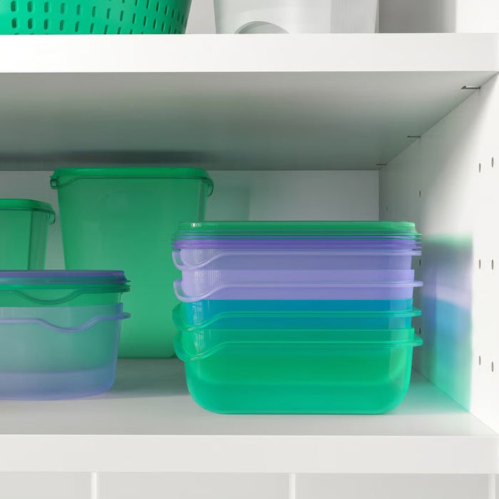 Two stackable IKEA PRUTA plastic containers (22x14x5 cm) in pastel lilac and green colors, ideal for meal prep and lunch storage. 40596710