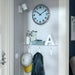 IKEA PUGG turquoise wall clock hanging on wall angled view