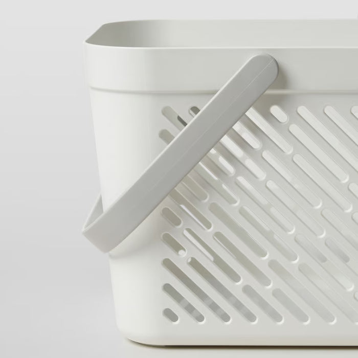 IKEA RÅNEN white plastic shower basket with drainage holes and folded handles, top-angle view