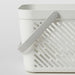 IKEA RÅNEN white plastic shower basket with drainage holes and folded handles, top-angle view