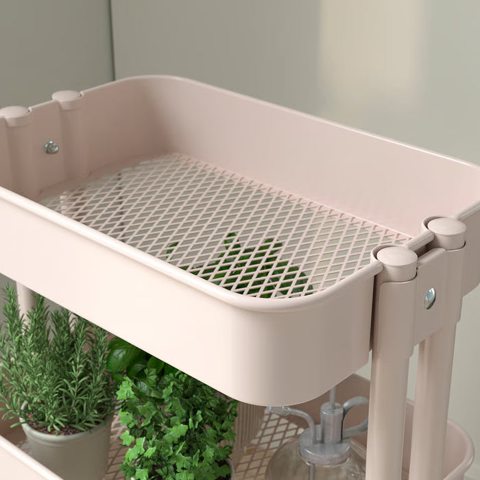  I: IKEA RÅSKOG pink trolley side view showing open mesh shelves and steel frame detail