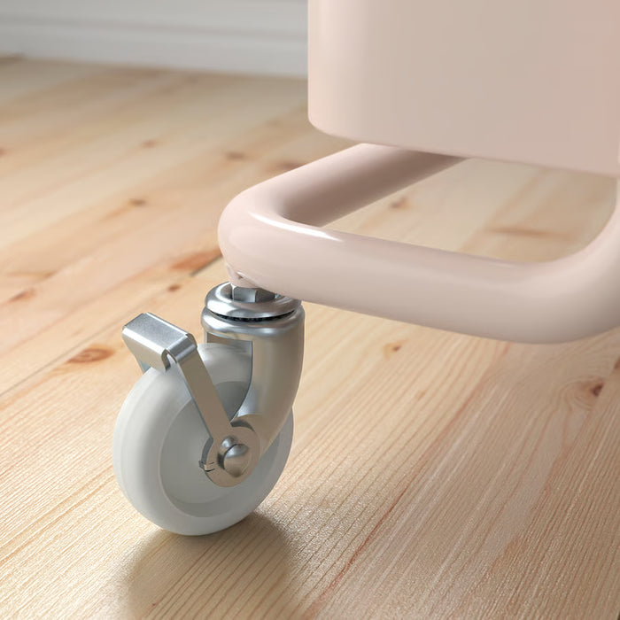 Close-up of IKEA RÅSKOG pink trolley lockable castor wheel and lower mesh shelf