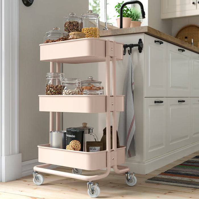 IKEA RÅSKOG pink trolley in kitchen setting holding spice jars and cooking essentials