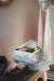 IKEA RENSARE grey packing cubes storing rolled clothes on a wooden shelf with hangers in background
