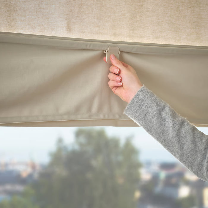  Person adjusting IKEA RINGBLOMMA beige roman blind near window for light and privacy control