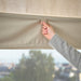 Person adjusting IKEA RINGBLOMMA beige roman blind near window for light and privacy control