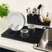 IKEA RINNIG black plate holder on kitchen counter with white plate, glasses and cutlery organiser