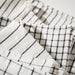 Close-up of IKEA RINNIG white dark grey striped tea towel showing flatwoven cotton texture
