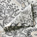 Close-up of IKEA RODGERSIA grey white paisley flat sheet showing intricate floral print and fabric texture