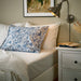 IKEA RODGERSIA blue paisley pillowcase styled on cream bed with white bedside table flowers and lamp