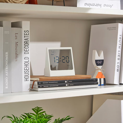 IKEA RÖDBENA alarm clock on bookshelf showing time 13:20 in living room setting