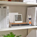 IKEA RÖDBENA alarm clock on bookshelf showing time 13:20 in living room setting