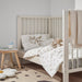  IKEA RÖDHAKE white rabbit print duvet cover styled on a cot in a cosy child's bedroom with plush toys