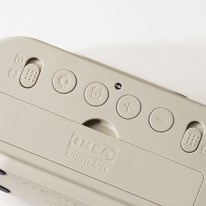 Close-up of a beige electronic device with buttons and the IKEA logo on a white background