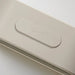 Close-up of a minimalist light switch panel with sun, moon, and alarm icons on a warm off-white surface.