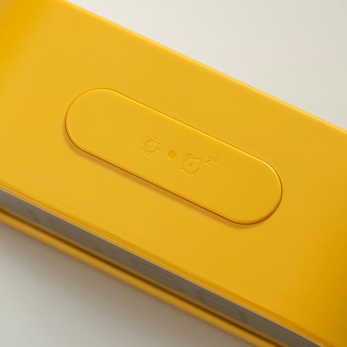Yellow alarm clock display showing time icons and light settings close-up