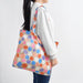 Person wearing IKEA ROMELSÖN bright polka dot bag over shoulder in everyday carry setting