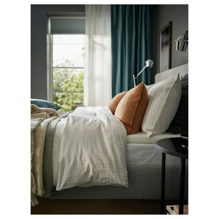 Modern bedroom window dressed with SANELA velvet curtains beside a plant and radiator