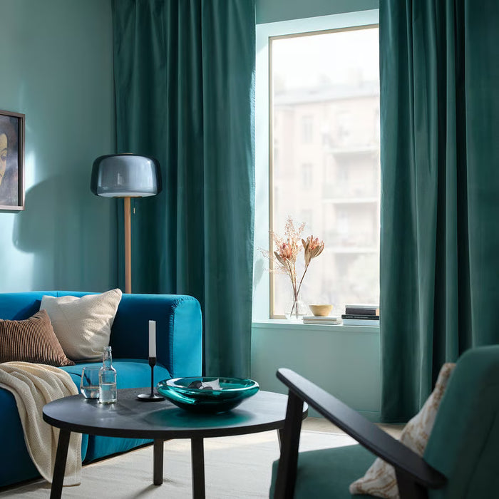 Teal living room styled with SANELA velvet curtains, blue sofa and floor lamp