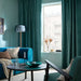 Teal living room styled with SANELA velvet curtains, blue sofa and floor lamp
