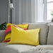 IKEA SANELA light yellow velvet cushion on sofa with grey curtain and lamp