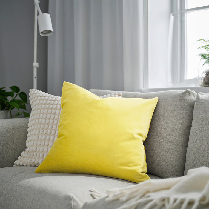 IKEA SANELA light yellow cushion cover styled on grey sofa near window