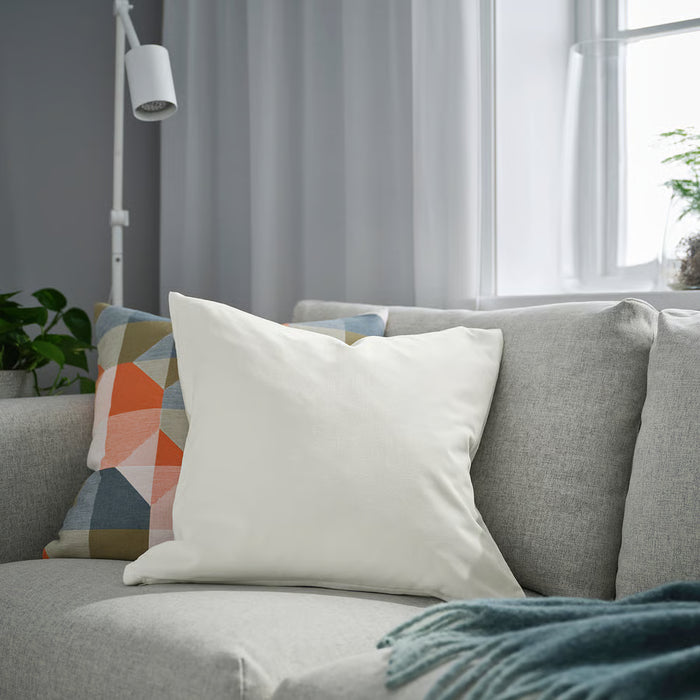 IKEA SANELA off-white velvet cushion styled on sofa with colourful accent cushions