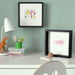  IKEA SANNAHED black frame standing vertically on a shelf displaying a 25x25 cm photograph