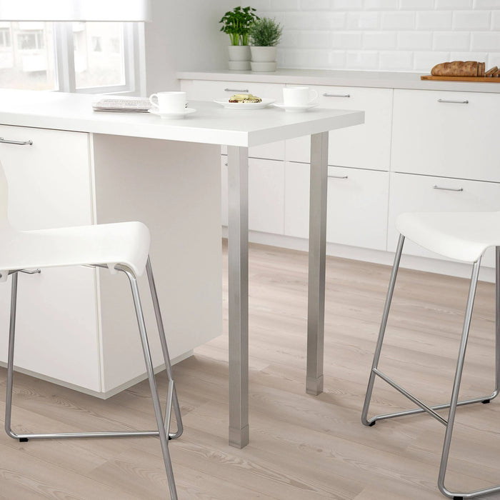 White kitchen table with stools in a modern kitchen setting