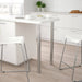White kitchen table with stools in a modern kitchen setting