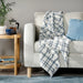 White and blue checkered IKEA SIKELVINGE Throw folded neatly on a chair 30573605