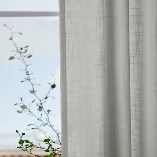 IKEA SILVERLÖNN light grey sheer curtains filtering natural daylight through window
