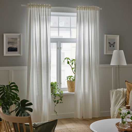 Two panels of IKEA SILVERLÖNN white sheer curtains displayed together in a bright living room setting
