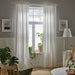 Two panels of IKEA SILVERLÖNN white sheer curtains displayed together in a bright living room setting