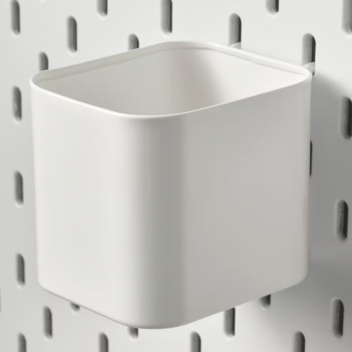 IKEA SKÅDIS white container on a white pegboard with other SKÅDIS accessories for organised workspace

