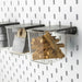 IKEA SKÅDIS clear containers with black lids hanging on pegboard storing craft supplies